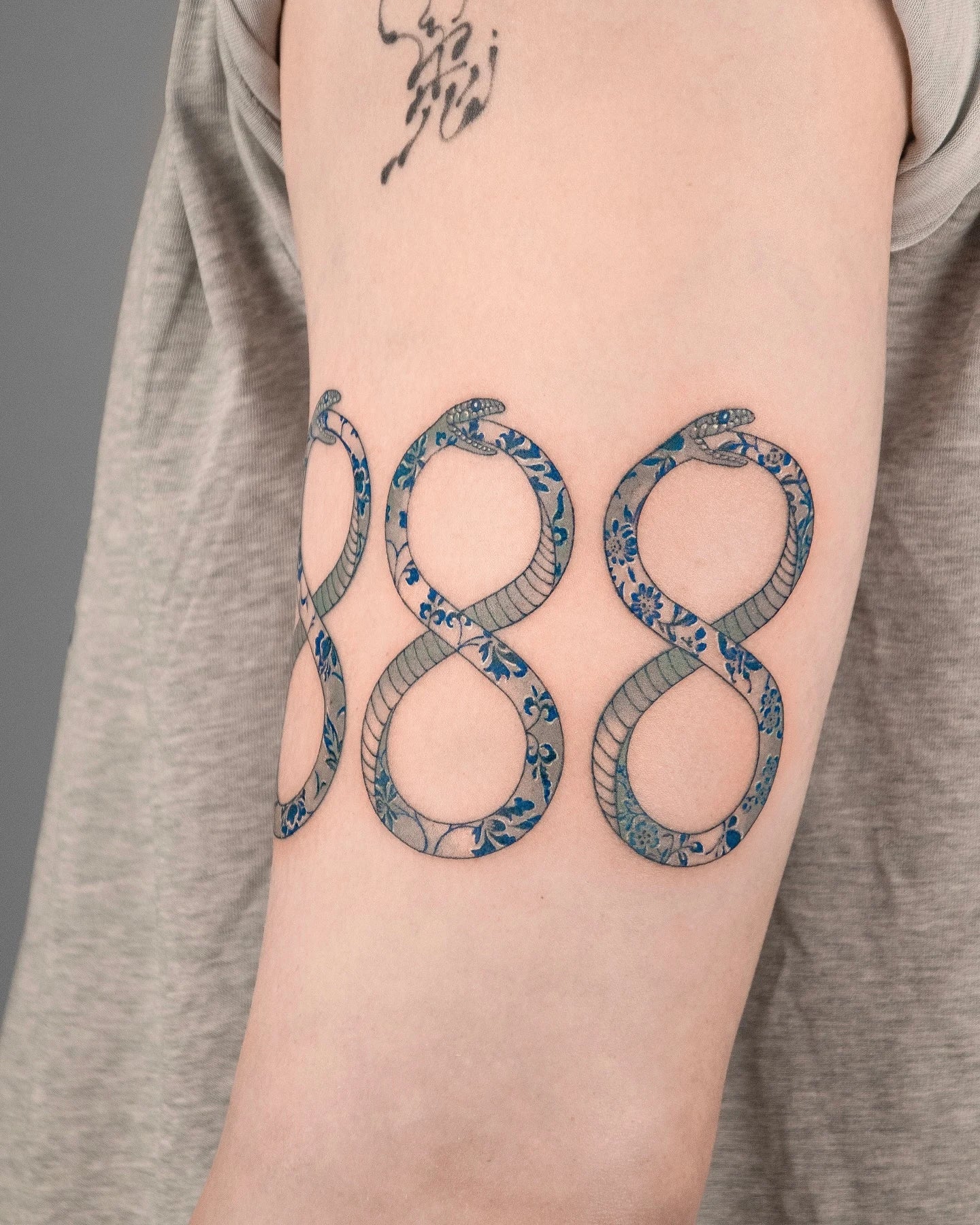 chinese style porcelain infinity snakes number eight tattoo on upper arm