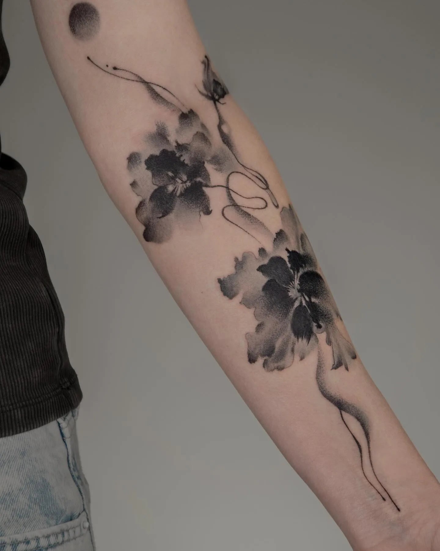 Chinese black watercolor flower tattoo on woman forearm