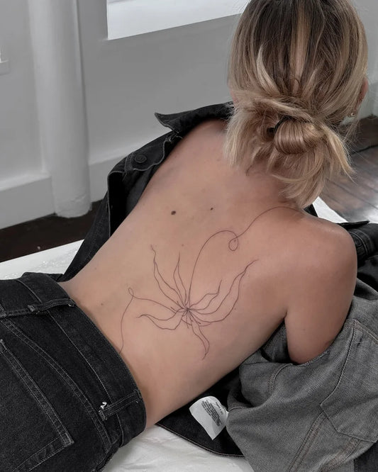 abstract one line flower woman back tattoo