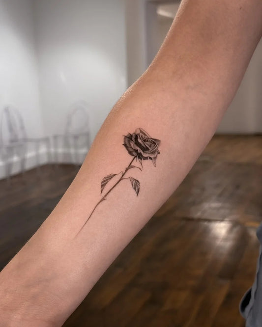 black and grey rose flower forearm tattoo