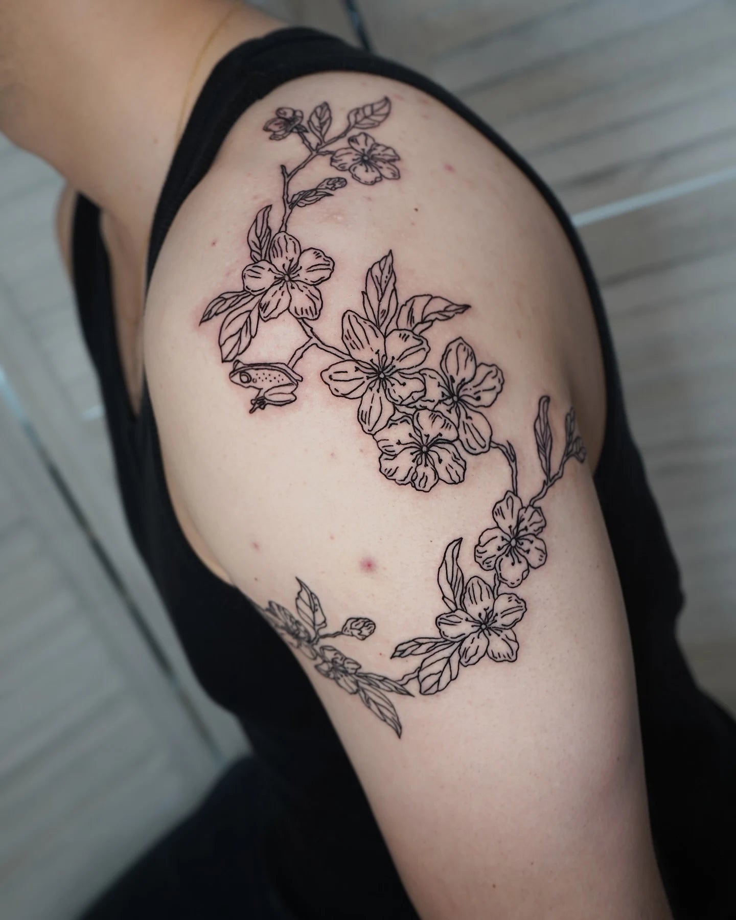 floral outline tattoo on man shoulder