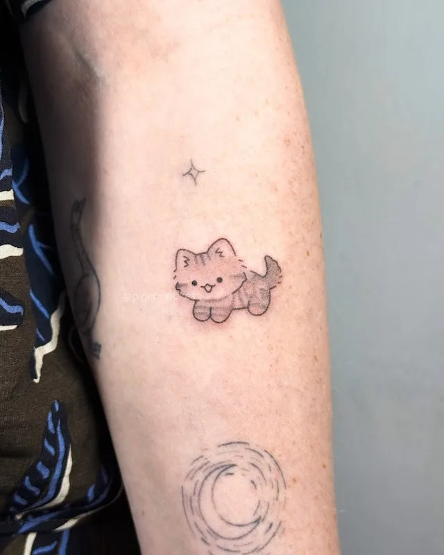 cute brown kitty cat hand poke tattoo on woman arm