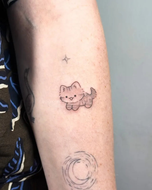 cute brown kitty cat hand poke tattoo on woman arm