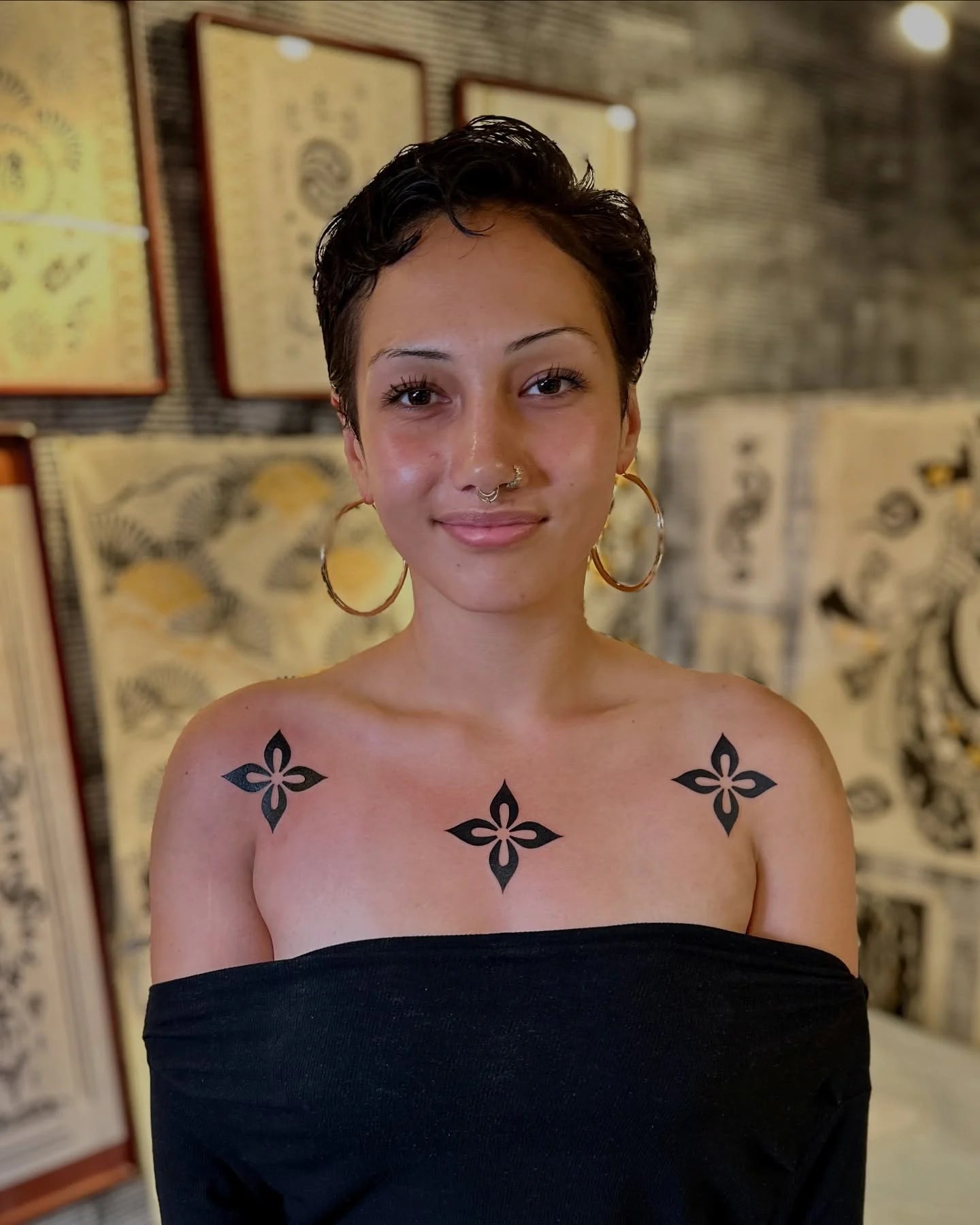 three blackwork floral symbol tattoo on woman chest and shoulder