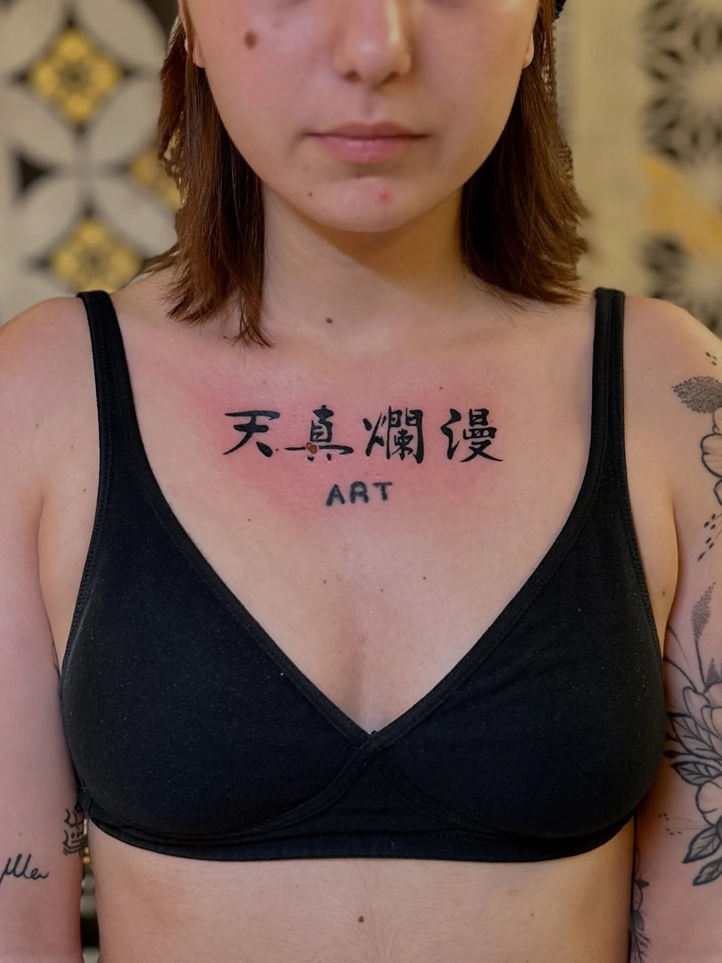 blackwork bold chinese lettering 天真爛漫 tattoo on woman chest