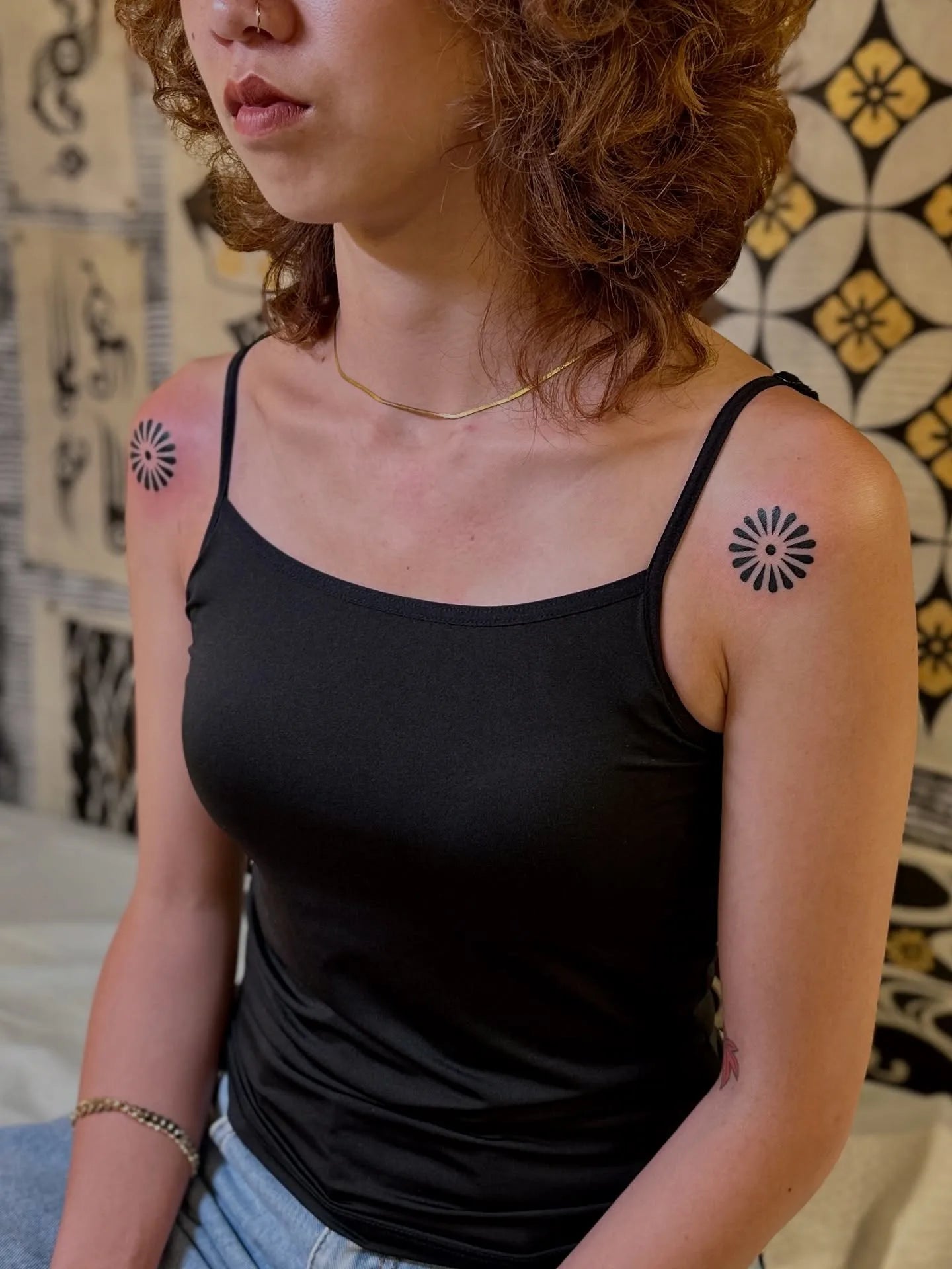 matching blackwork circle pattern tattoos on woman shoulder