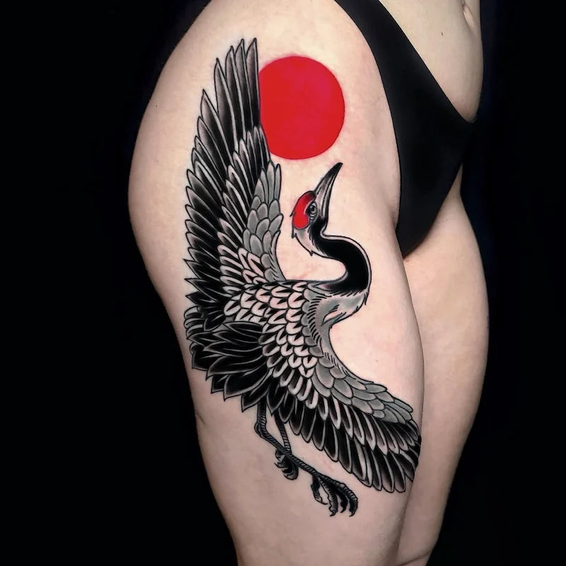 black crane and red sun japanese tattoo on woman thigh