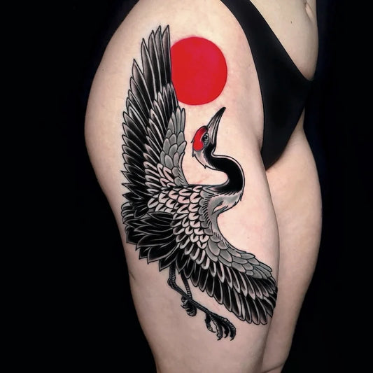 black crane and red sun japanese tattoo on woman thigh