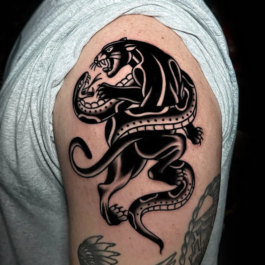 black panther and snake fighting traditional tattoo on man upper arm