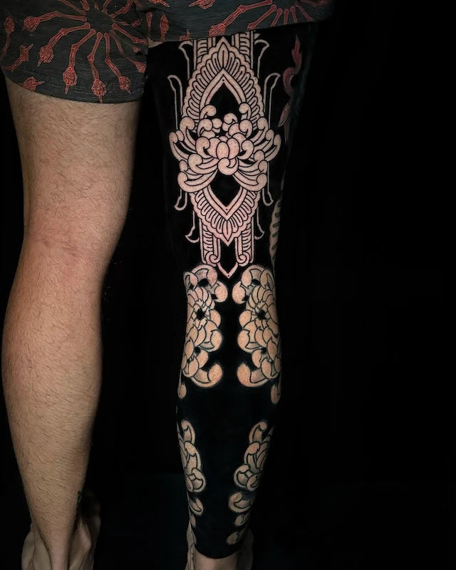 blackwork lotus flower tattoo on man full leg sleeve