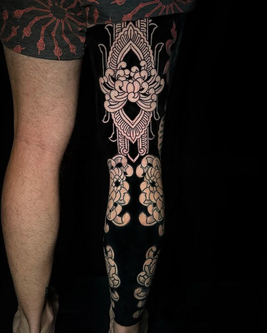 blackwork lotus flower tattoo on man full leg sleeve