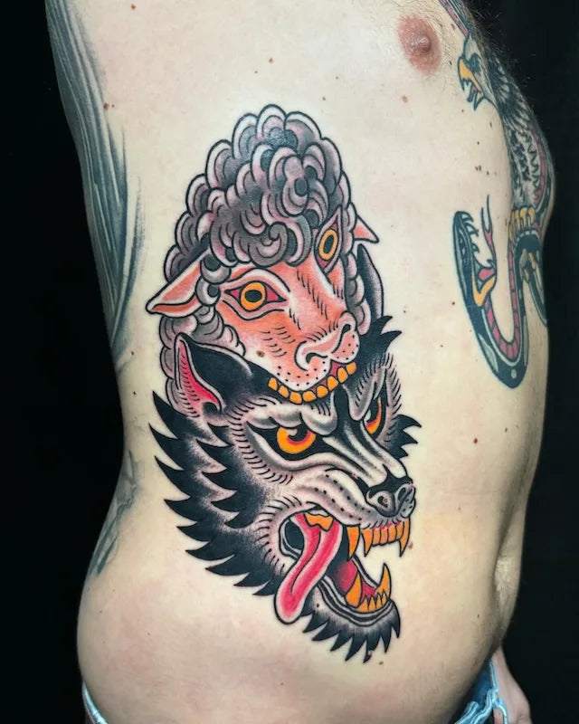 traditional sheep eating wolf tattoo on man rib