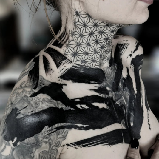 blackwork geometric tattoo on woman neck and chest