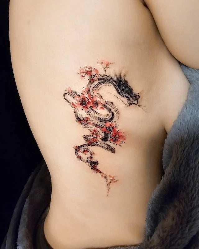 abstract dragon with cherry blossom watercolor tattoo on woman rib