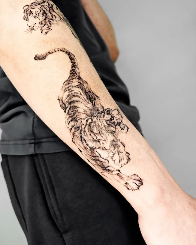 black watercolor oriental tiger tattoo on man forearm