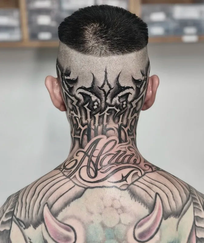 black bold lettering tattoo on back of neck head