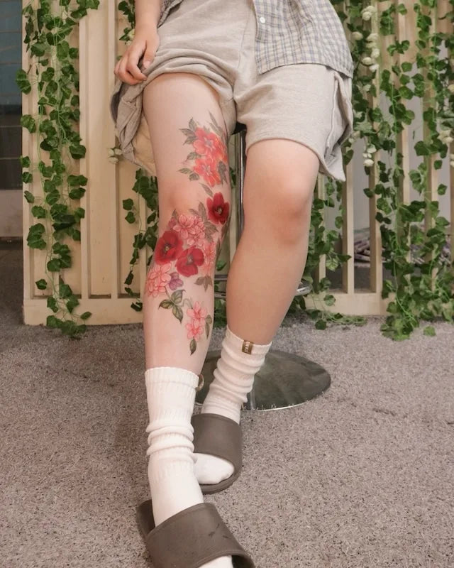 colorful floral tattoo on woman leg sleeve