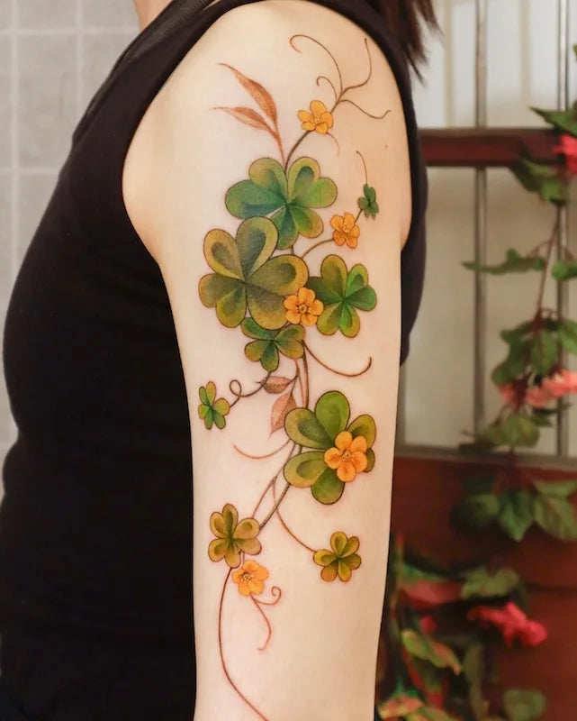green ivy vine tattoo on woman upper arm sleeve