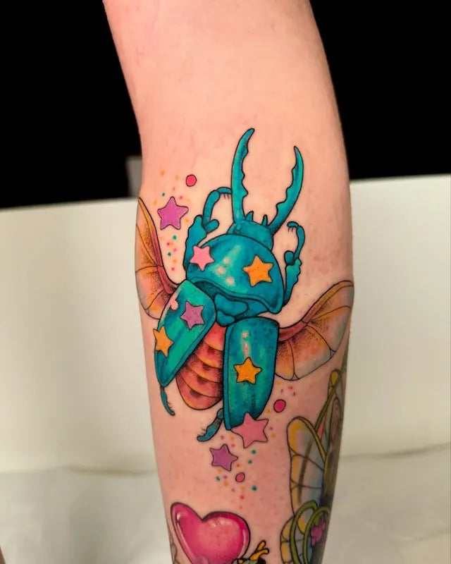 Colorful tattoo of a beetle with stars