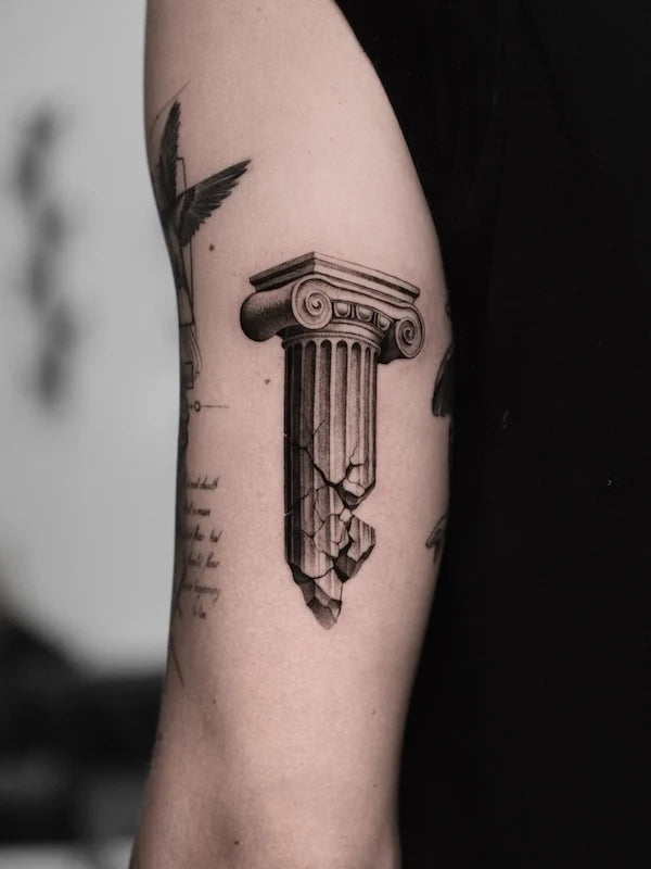 black and grey realism column greek architecture tattoo on upper arm