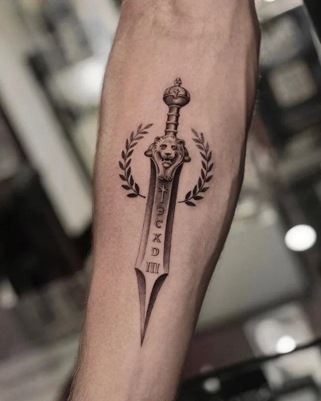 black and grey realism tattoo of a lion sword with laurel leaves on forearm