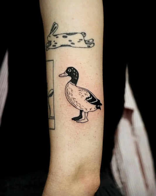 black and white duck goose tattoo on woman upper arm