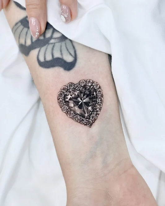 black heart-shaped diamond gem color realism tattoo on woman wrist