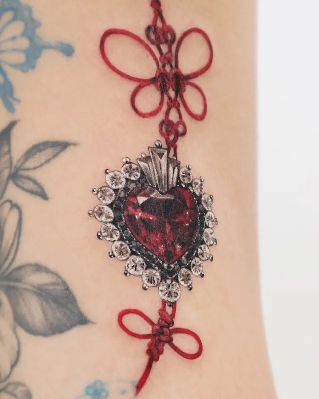 color realism tattoo of a red heart with a bow knot