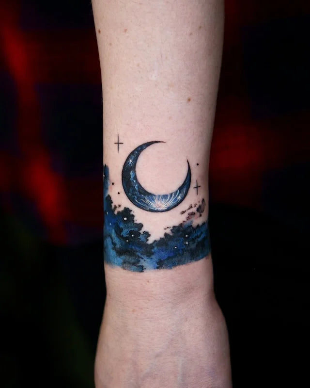 watercolor dark blue moon and starry sky wrist wrap tattoo