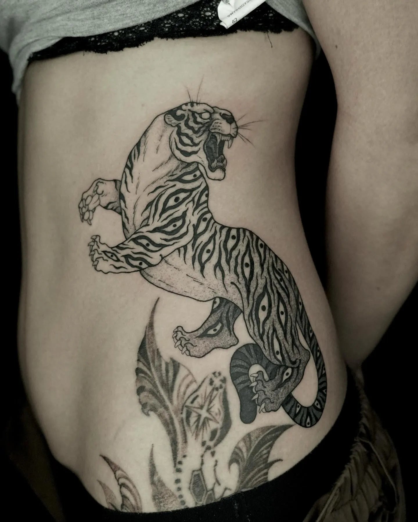 big dotwork tiger tattoo on woman side rib stomach