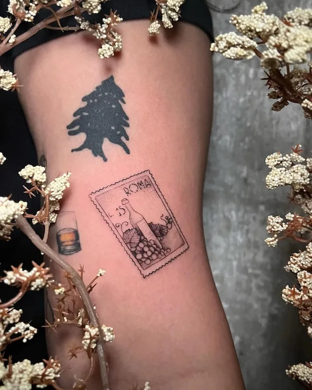 Rome Roma postage stamp black and grey tattoo on arm