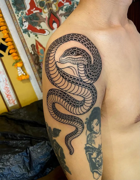 thai traditional Unalome snake tattoo on man upper arm shoulder