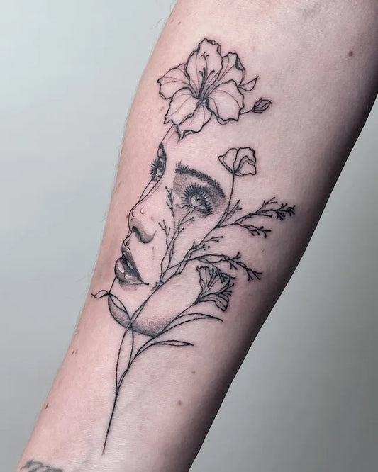 abstract floral woman face fine line tattoo on forearm