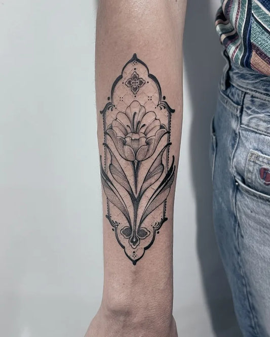 black and grey decorative floral tattoo on woman forearm