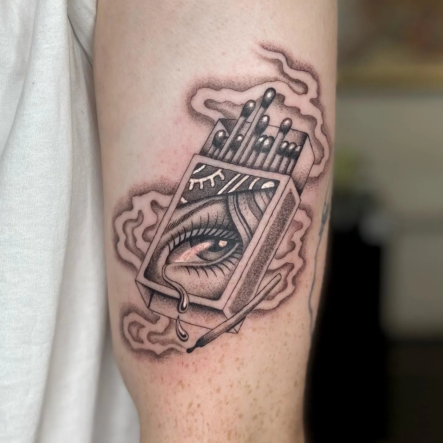 match box with eye and smoke tattoo