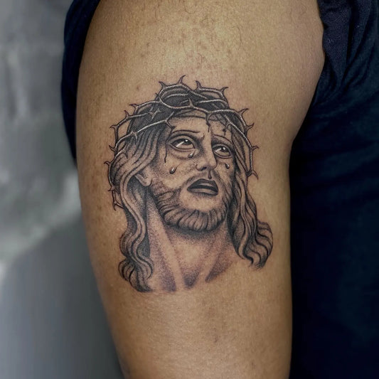 black and grey Jesus with tears tattoo on man upper arm