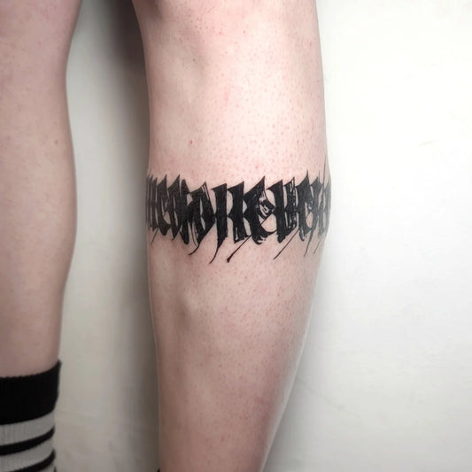 blackwork lettering leg wrap band tattoo
