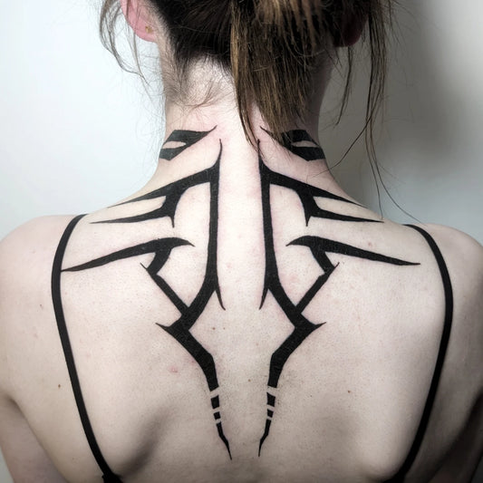 blackwork tribal tattoo on woman neck and back