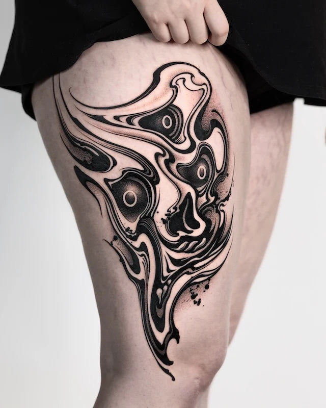 abstract blackwork skull tattoo on woman thigh