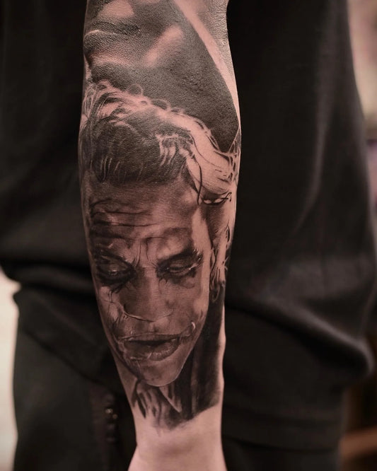 realism joker portrait forearm tattoo