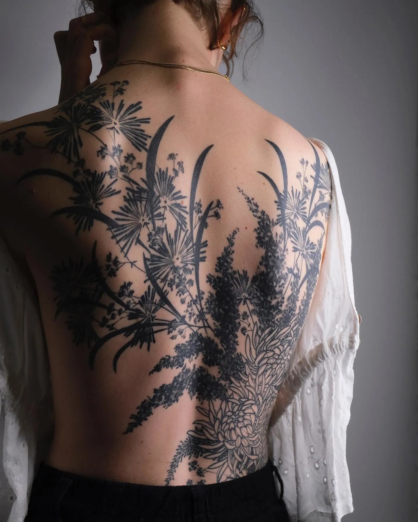 blackwork flowers woman full back tattoo