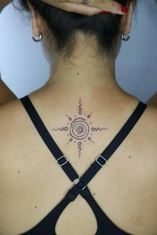 simple thai sak yant sun tattoo on woman back