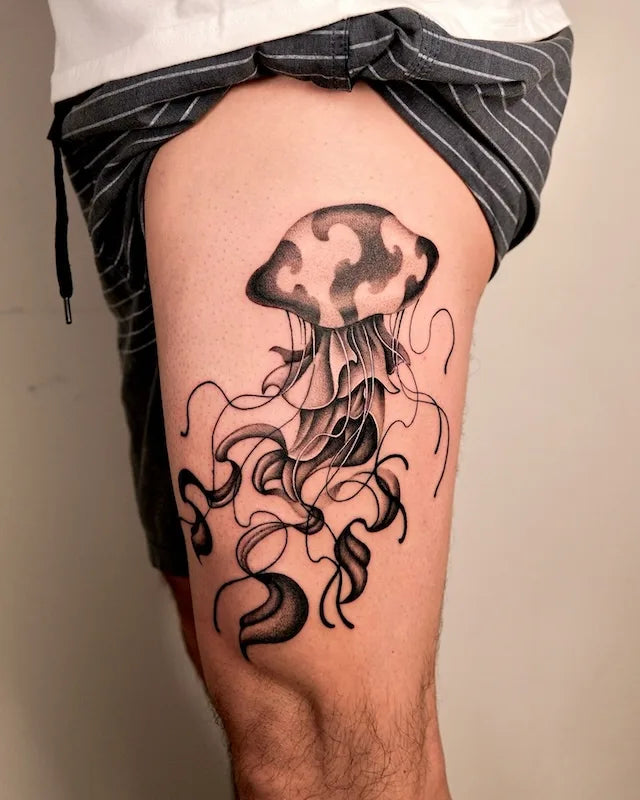 big jellyfish black and grey tattoo on man side thigh
