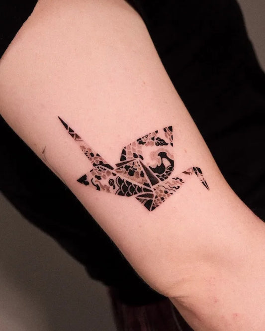 floral paper crane tattoo on upper arm