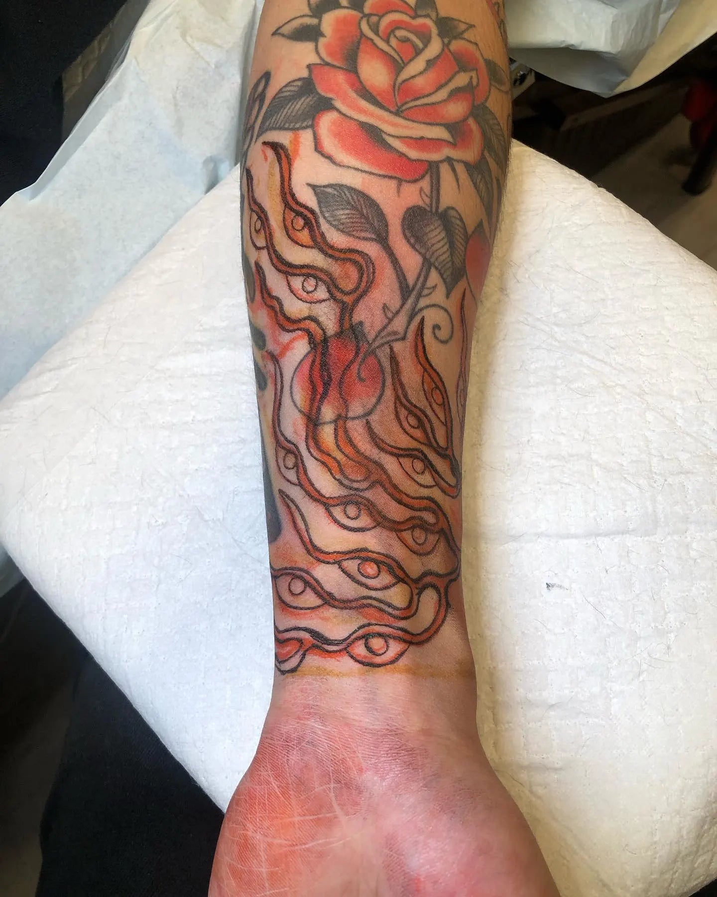 japanese creepy fire eyes abstract tattoo on man forearm