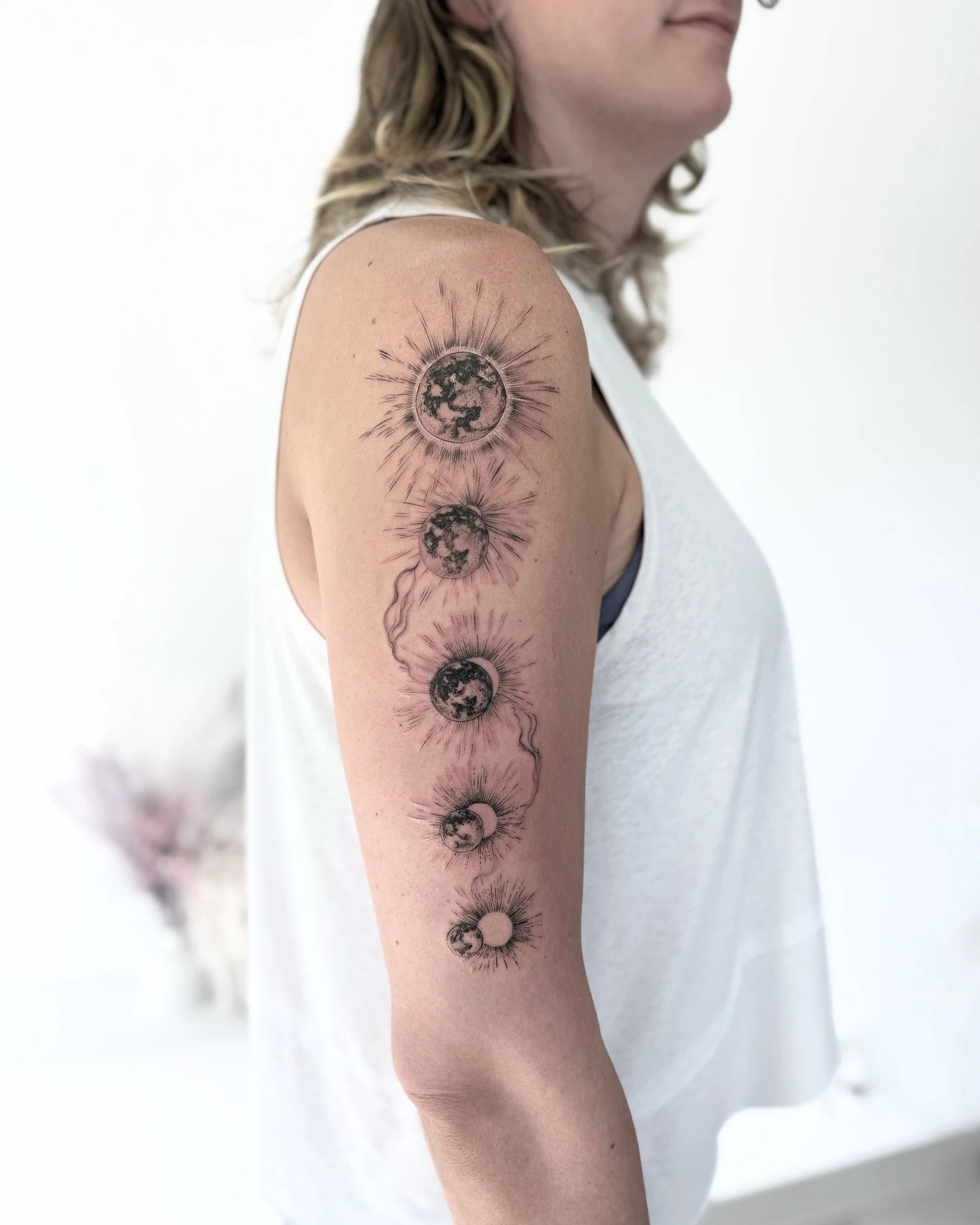 Solar Eclipse sun moon phase upper arm tattoo