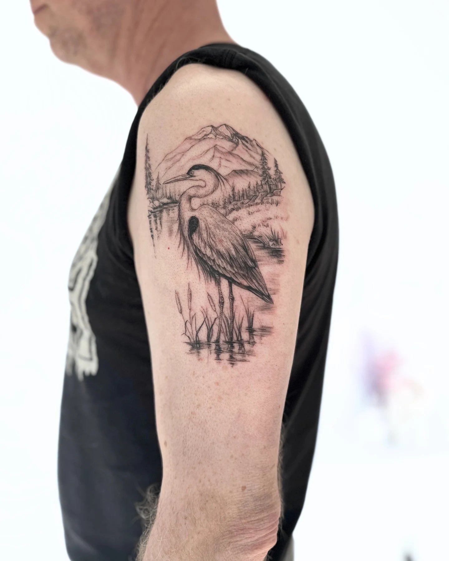 heron and lake scene upper arm tattoo